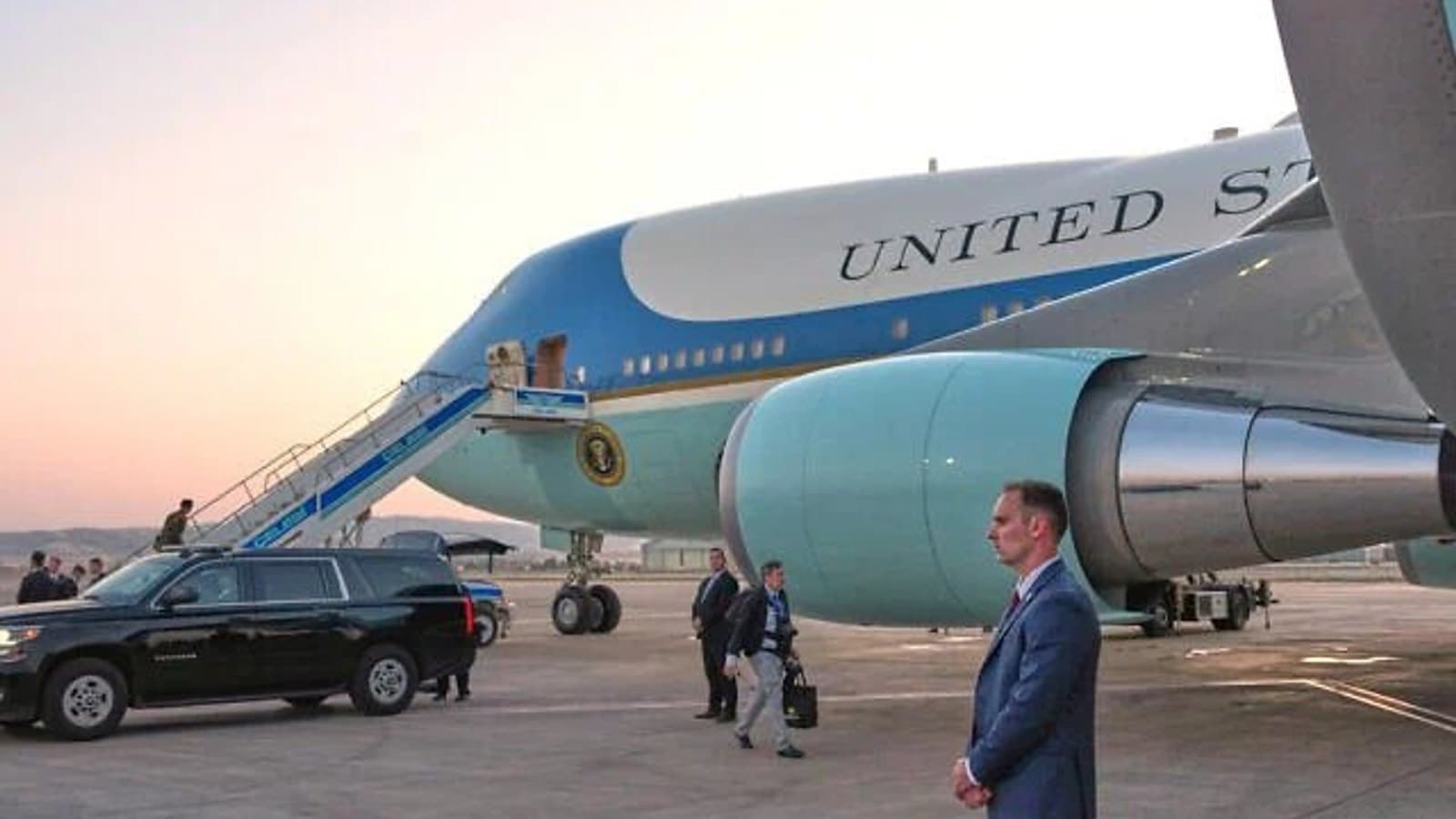 Air Force One on the tarmac at dusk with security personnel alongside. File photograph. תצלום ארכיון.