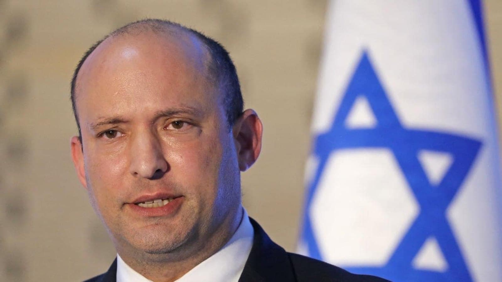 Naftali Bennett photographed in front of a blurred Israeli flag. תצלום ארכיון.
