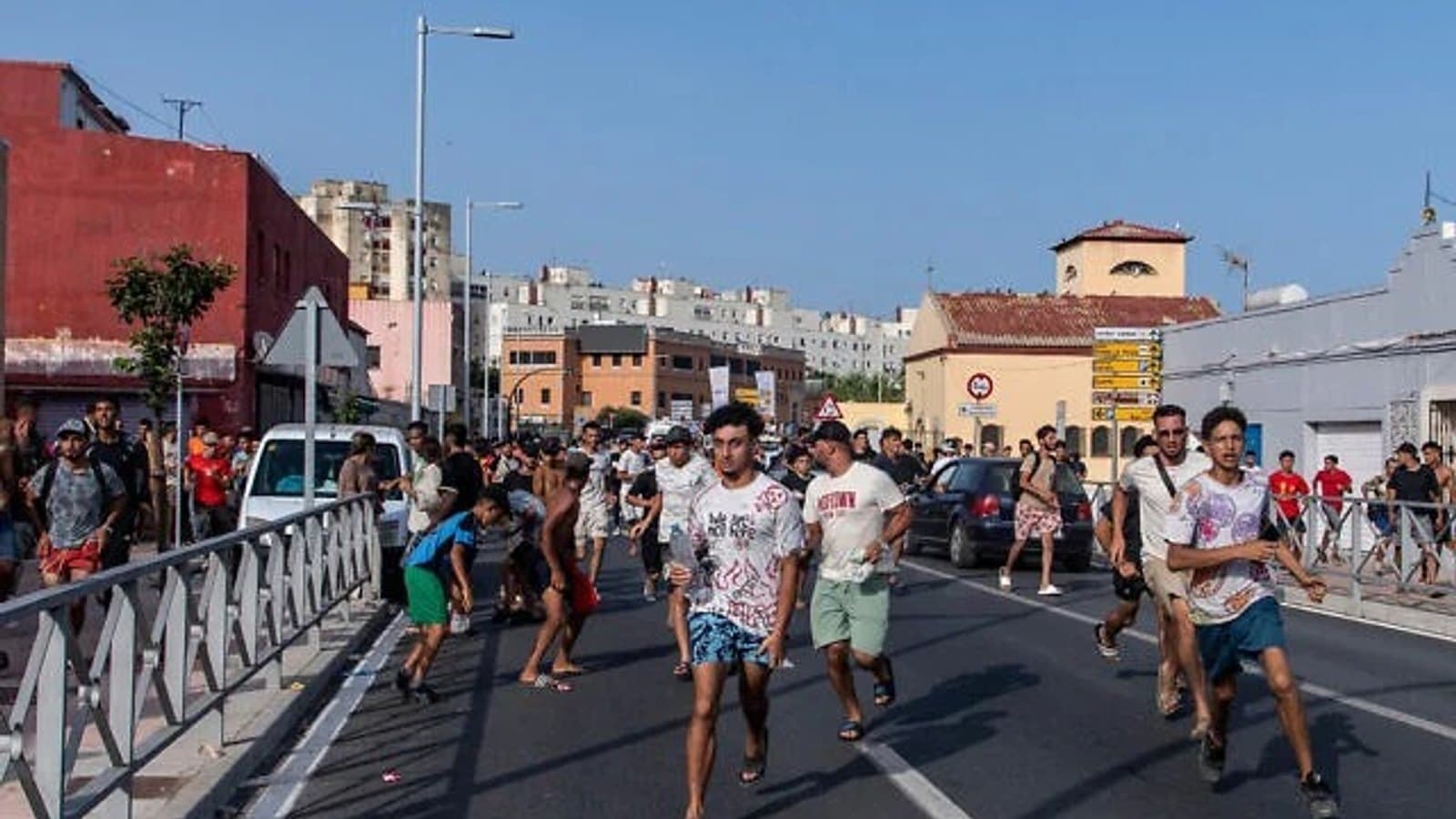 People run along a road in Ceuta after crossing from Morocco. File photograph.