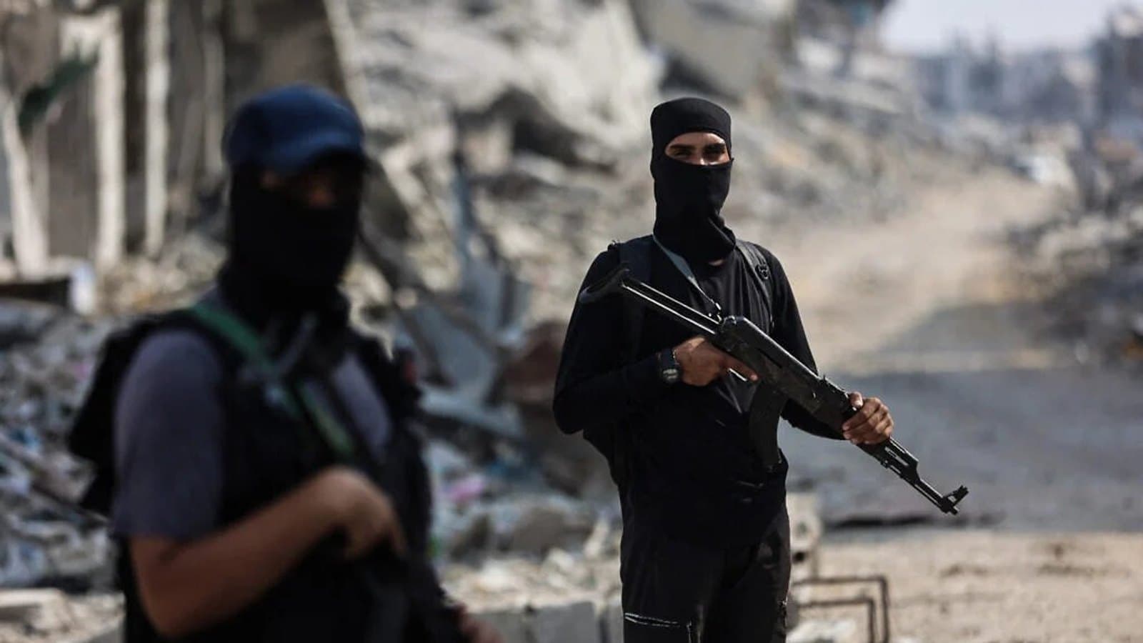 Armed men stand on a cleared road between destroyed buildings in Gaza. File photograph. תצלום ארכיון.