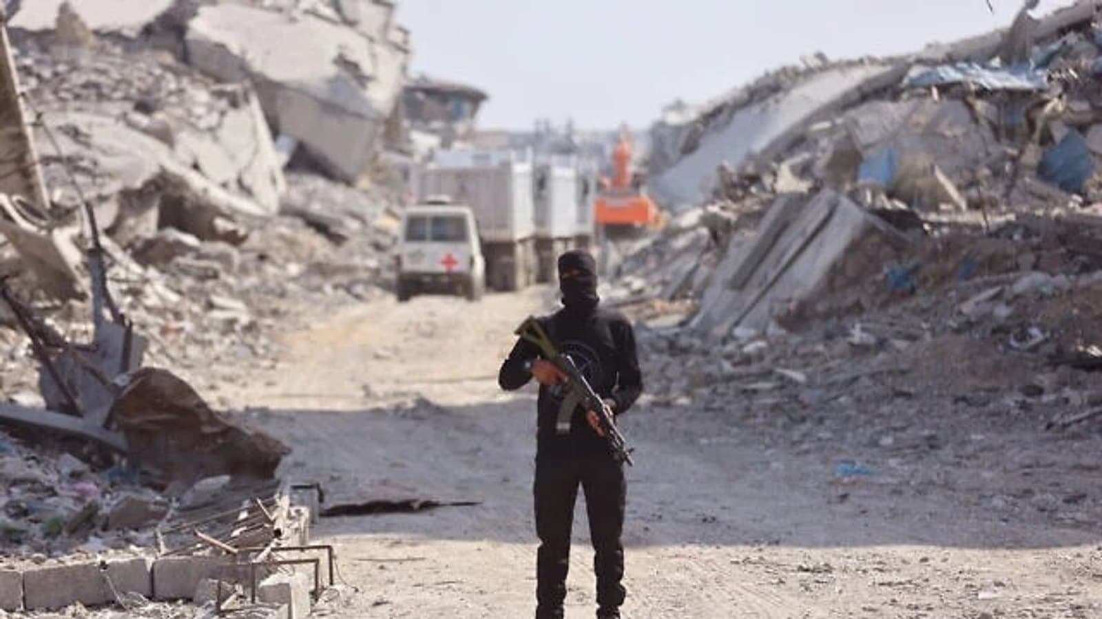 An armed man stands on a cleared road between collapsed buildings in Gaza. File photograph.