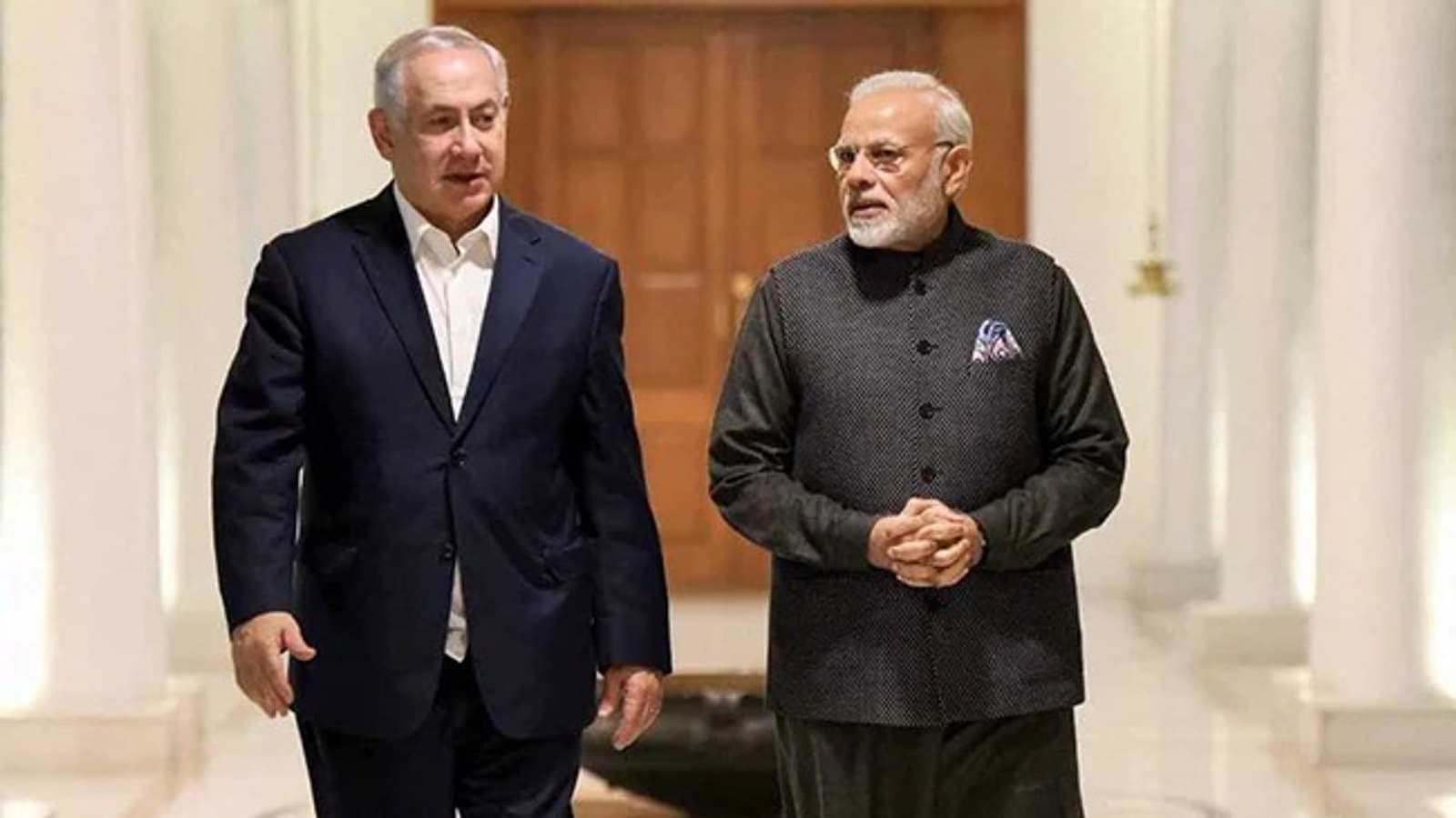 Prime Minister Netanyahu and Indian Prime Minister Narendra Modi walking together through a colonnaded hall. תצלום ארכיון.