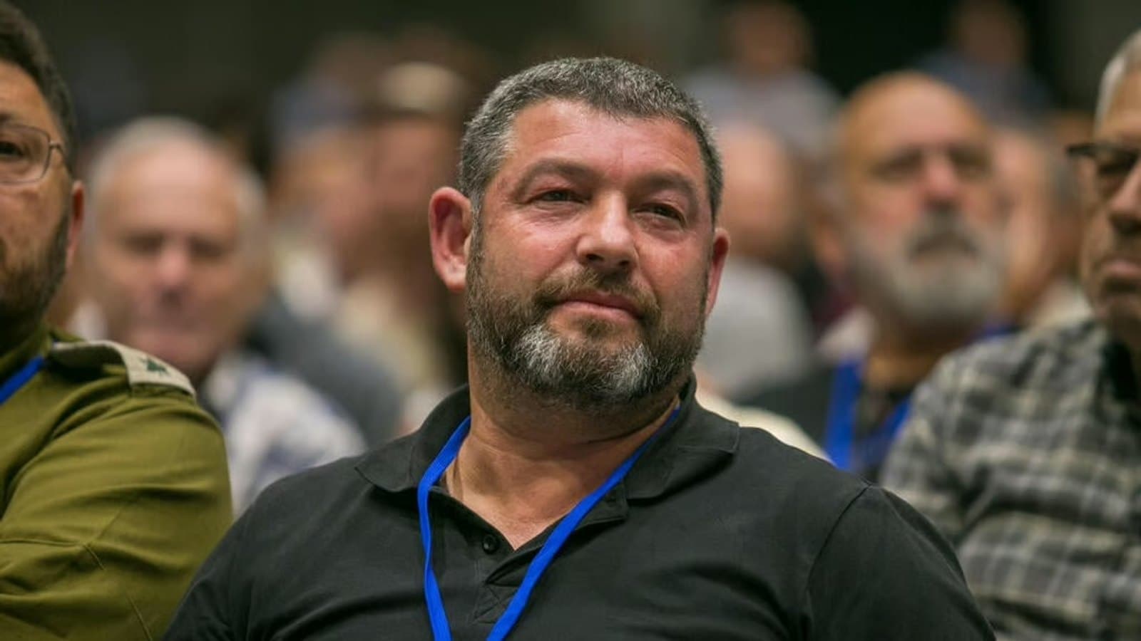 Ofer Winter seated in an audience, with an IDF officer visible beside him. תצלום ארכיון.