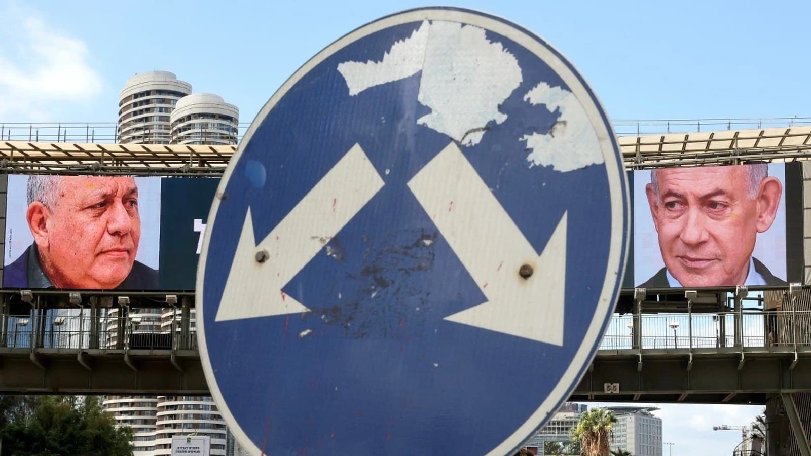 A road sign with arrows pointing in different directions, framed between large campaign billboards of Eisenkot and Netanyahu. תצלום ארכיון.