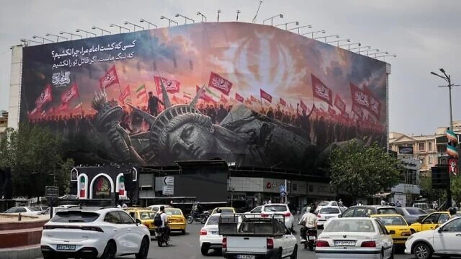 Traffic passes an anti-American mural on a Tehran square. File photograph. תצלום ארכיון.