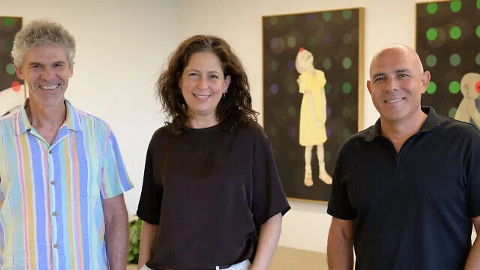 Three Weizmann Institute researchers standing together in a gallery space. תצלום ארכיון.