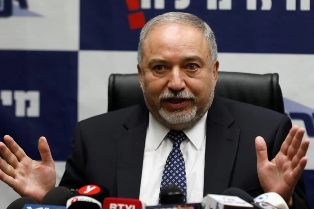 Avigdor Lieberman speaking at a press conference with microphones in front of him